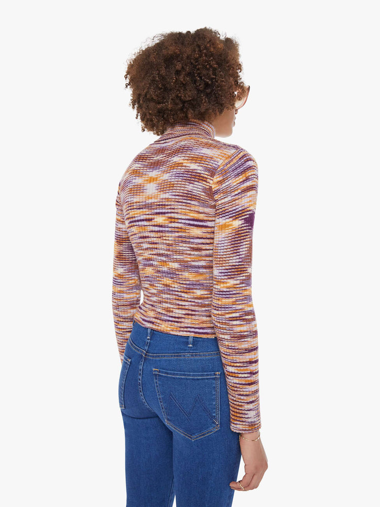 Back  view of a woman in a graphic stripe print in orange, maroon and white  long sleeve knit top features a turtleneck and a narrow fit. 