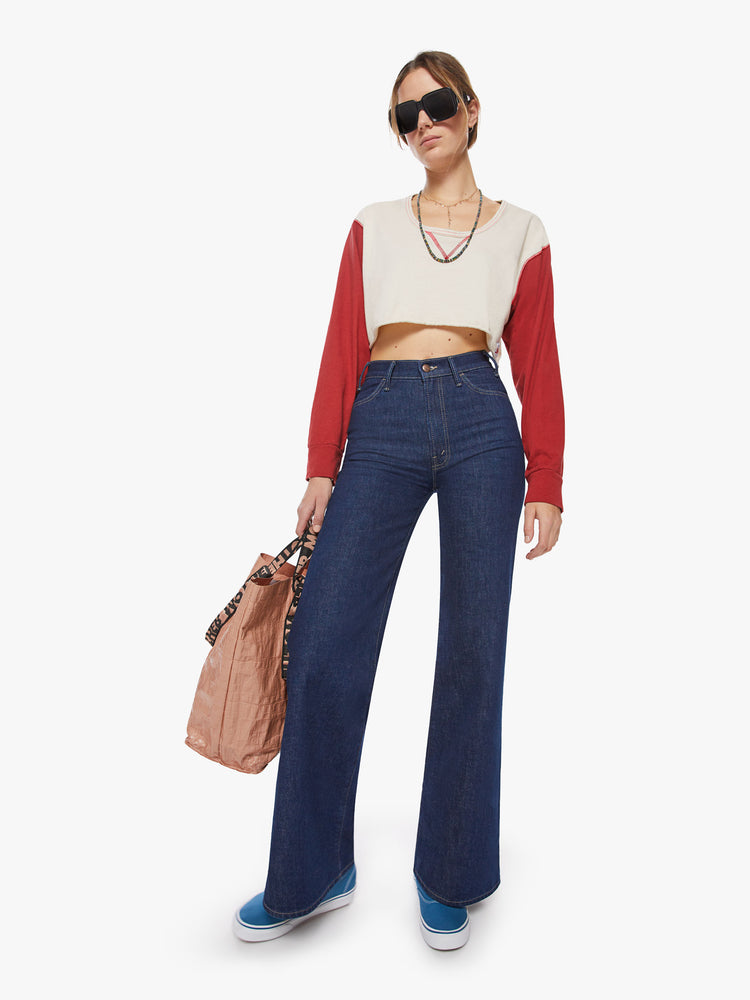 Full body view of a woman longsleeve tee with a scoop neck, long sleeves, drop shoulders and a super-cropped hem in an off-white hue with red sleeves.