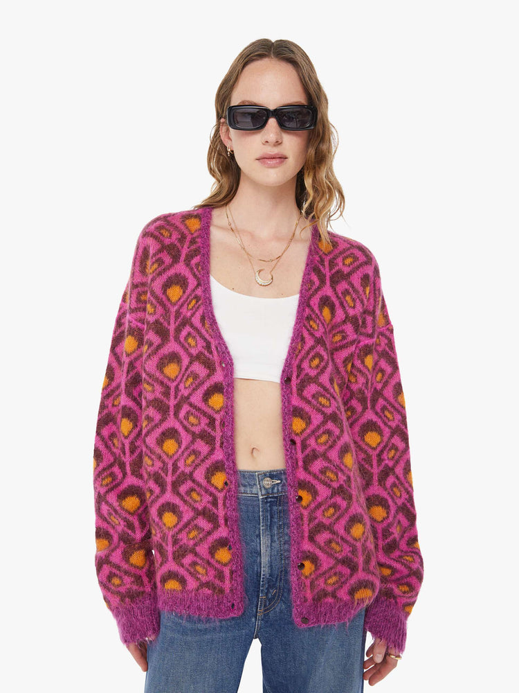 Front view of a woman in a two equally bold sides in an orange, salmon and purple reversible oversized cardigan features a V-neck, drop shoulders, ribbed hems and buttons down the front.