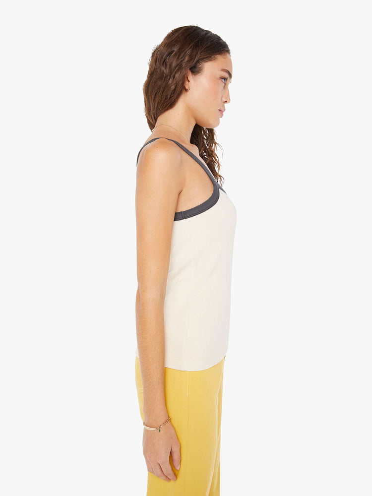 Side view of a woman in a vintage-inspired tank designed with thin straps, a narrow fit and a slightly longer hemline.