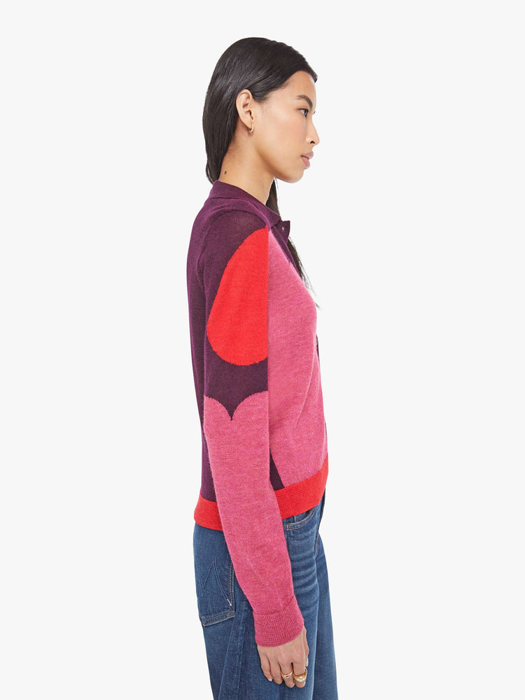 Side view of a maroon and pink collared cardigan sweater with long sleeves, ribbed hems and a loose fit. 