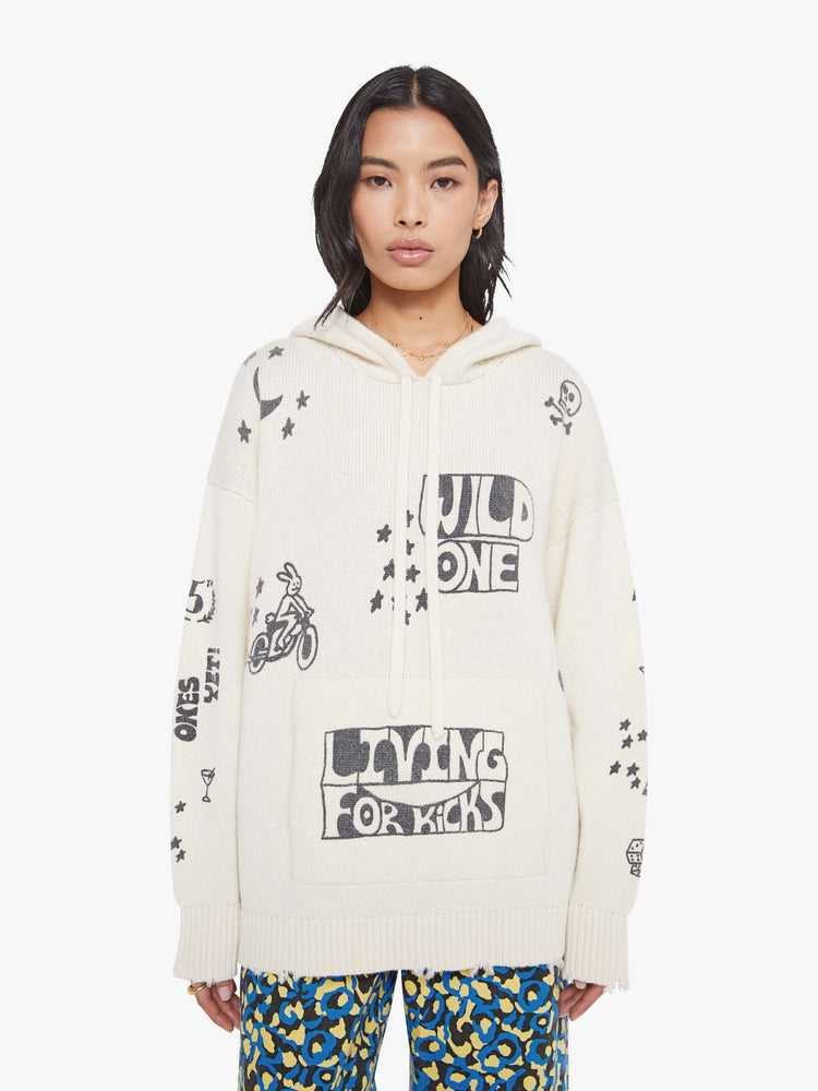 Front view of a woman in an  oversized knit hoodie with drop shoulders, a front patch pocket and ribbed hems with a distressed edge. 