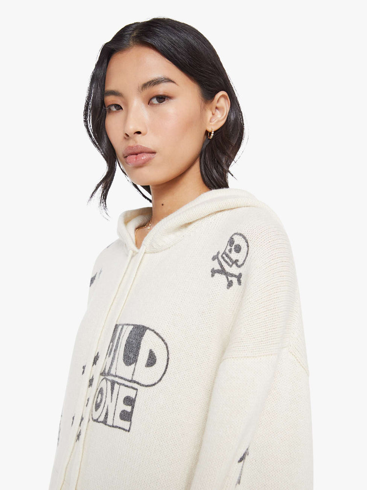 Close up view of a woman in an  oversized knit hoodie with drop shoulders, a front patch pocket and ribbed hems with a distressed edge. 