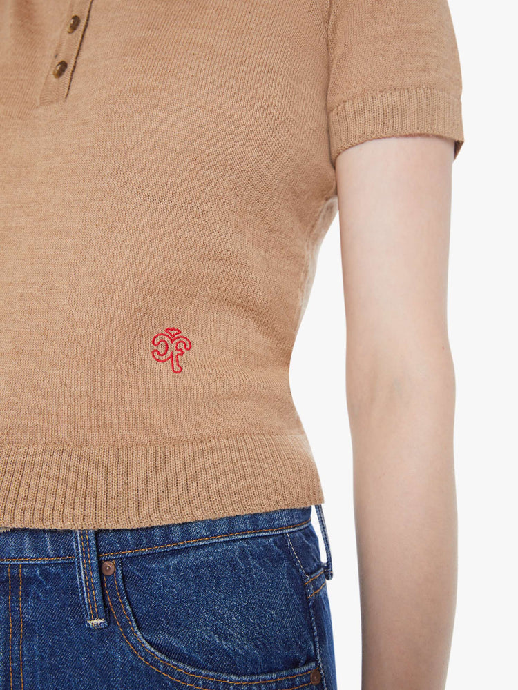 Swatch view of a woman in a light khaki with red details and trim knit polo shirt with short sleeves, a buttoned V-neck, ribbed hems and a slightly cropped fit.