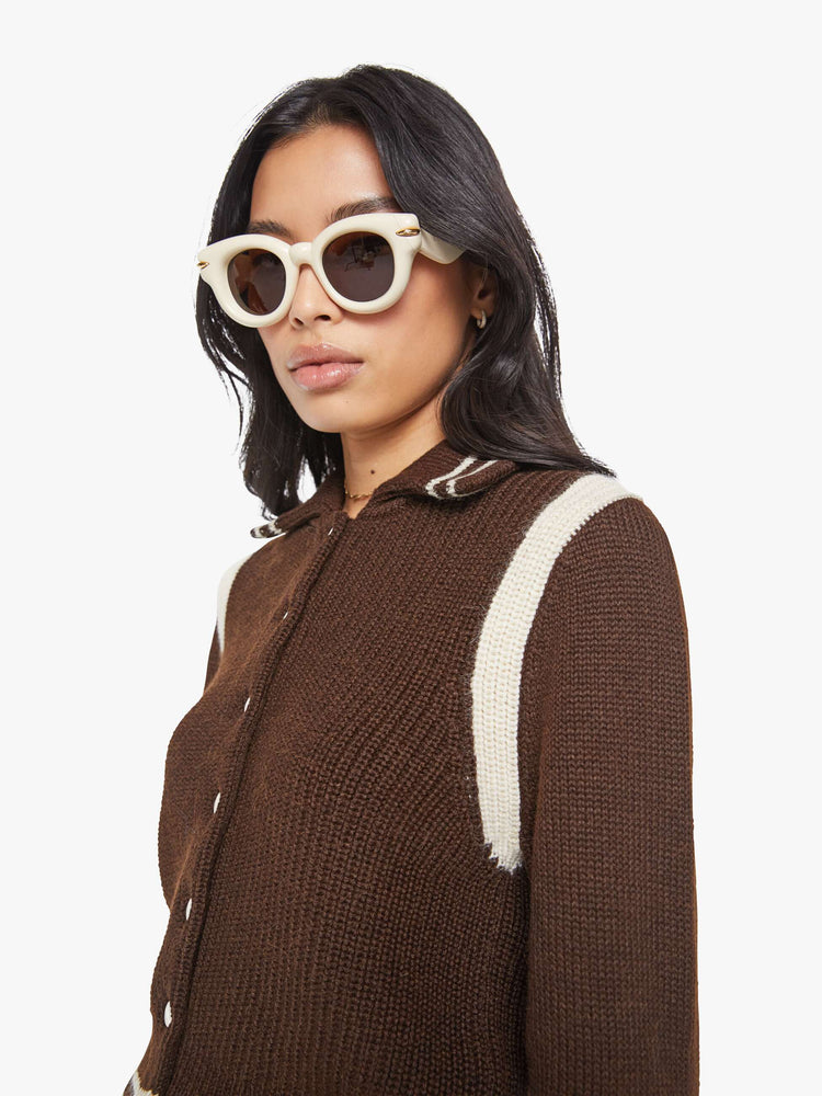 Close up view of a chocolate  collared knit top with long sleeves, buttons down the front, ribbed hems and a slightly shrunken fit. 