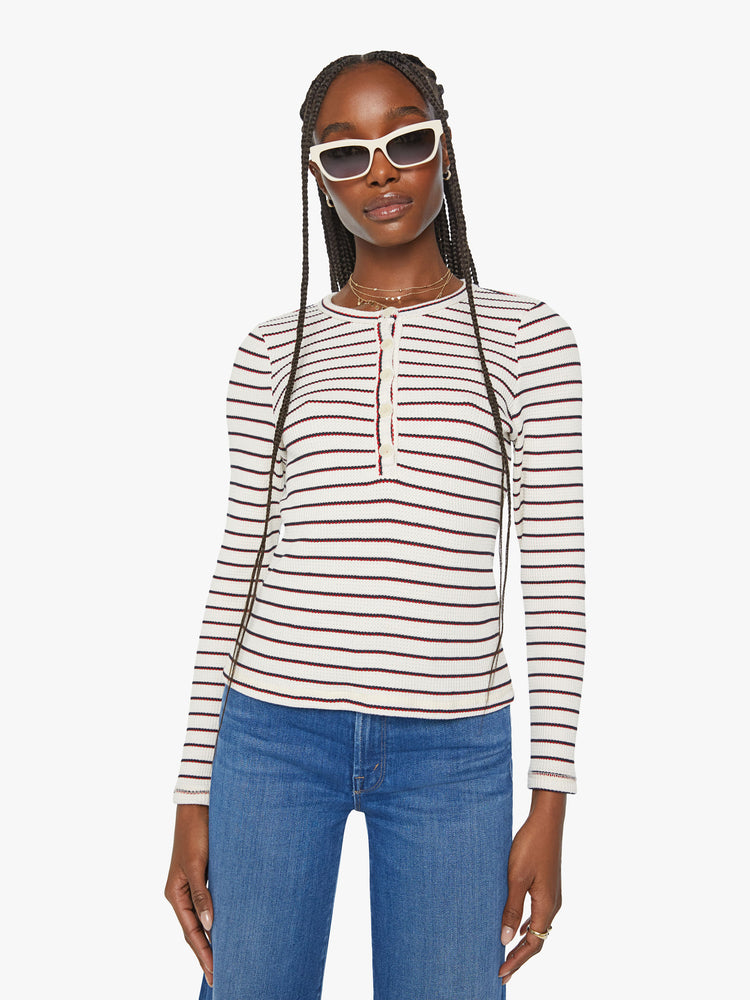 Front view of a woman  long sleeve thermal with a buttoned crewneck and a narrow fit in cream with navy and red stripes.