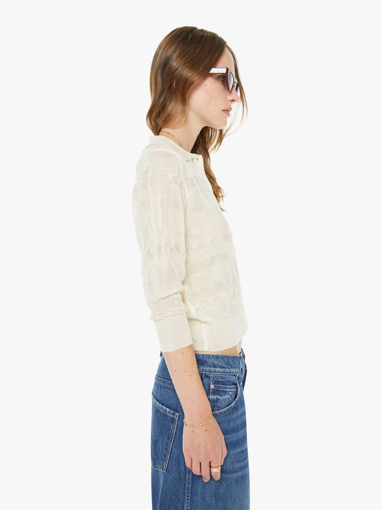 Side view of a woman in a collared long-sleeve top with a cropped fit and buttons down the front.