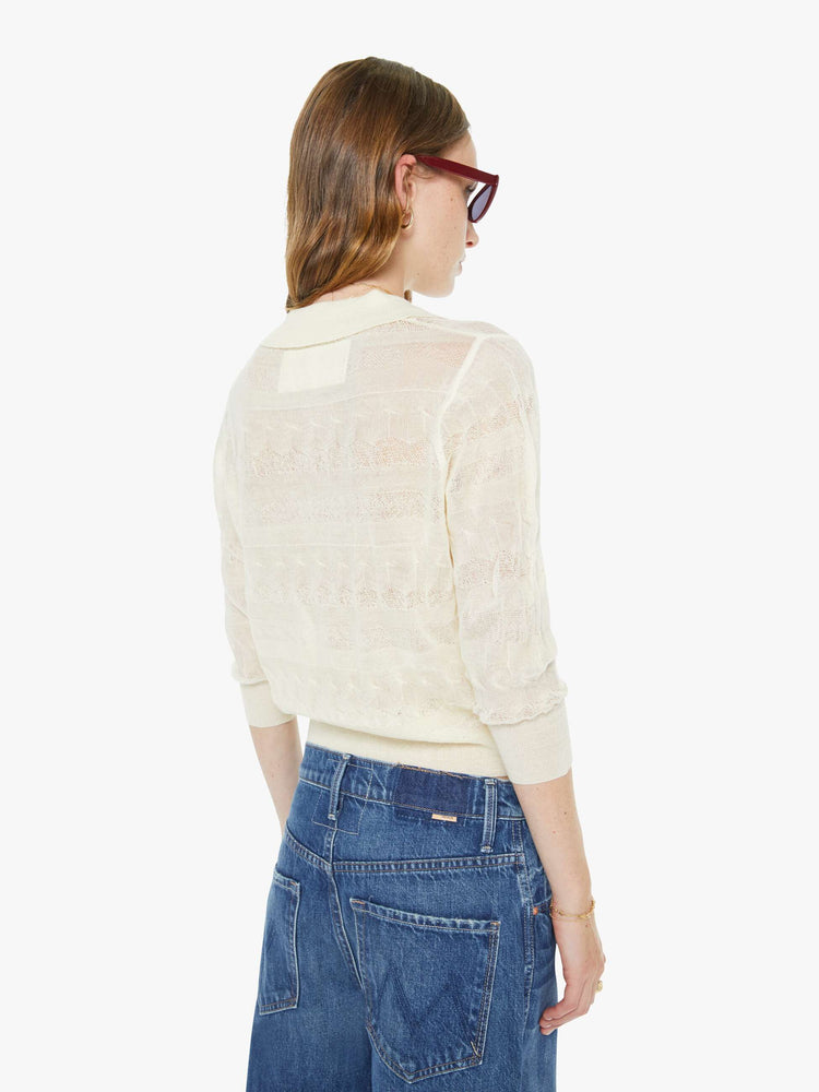 Back view of a woman in a collared long-sleeve top with a cropped fit and buttons down the front.