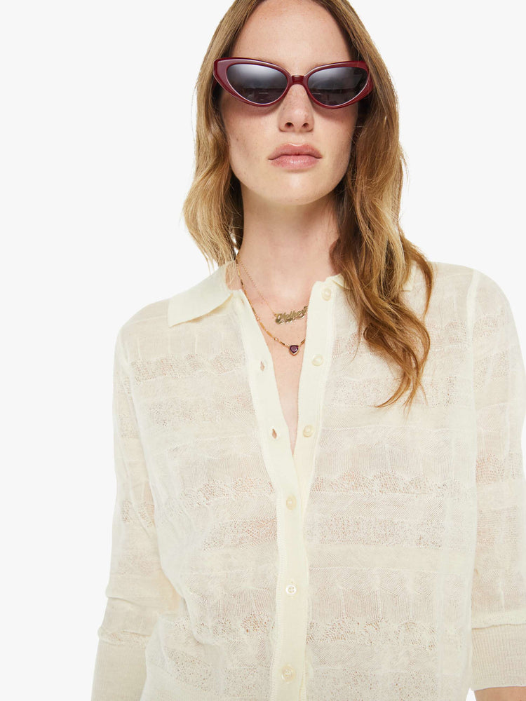 Close up view of a woman in a collared long-sleeve top with a cropped fit and buttons down the front.