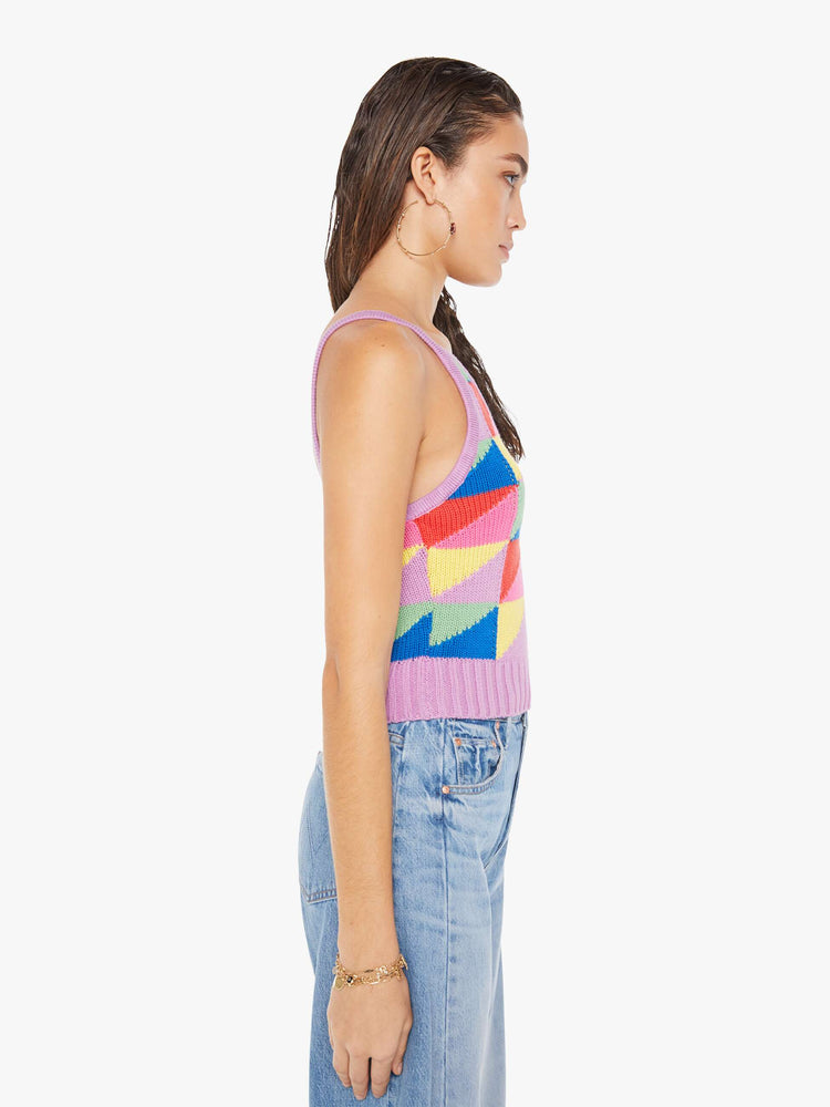 Side view of a woman wearing a colorful knit tank top featuring a geometric triangle pattern with bright purple trim.