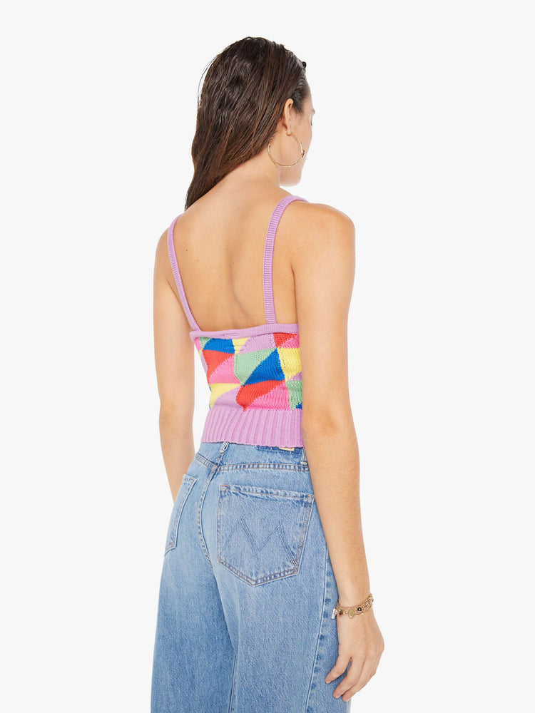 Back view of a woman wearing a colorful knit tank top featuring a geometric triangle pattern with bright purple trim.