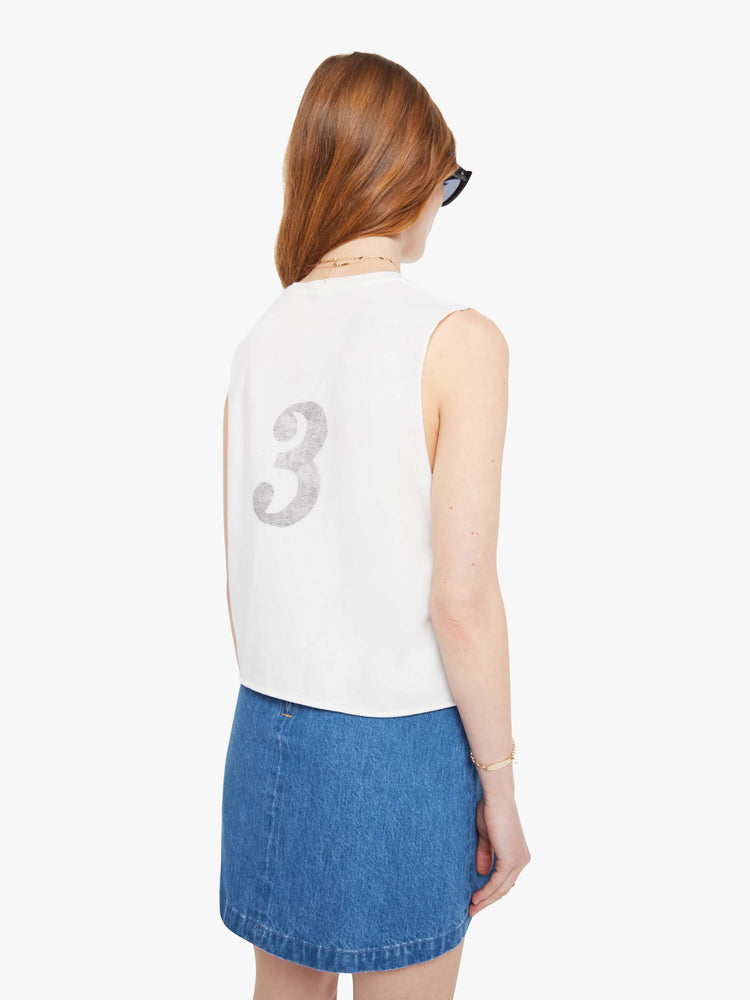 Back  view of a woman in a slightly sheer crewneck with chopped sleeves and a slim fit for a vintage look and feel. 