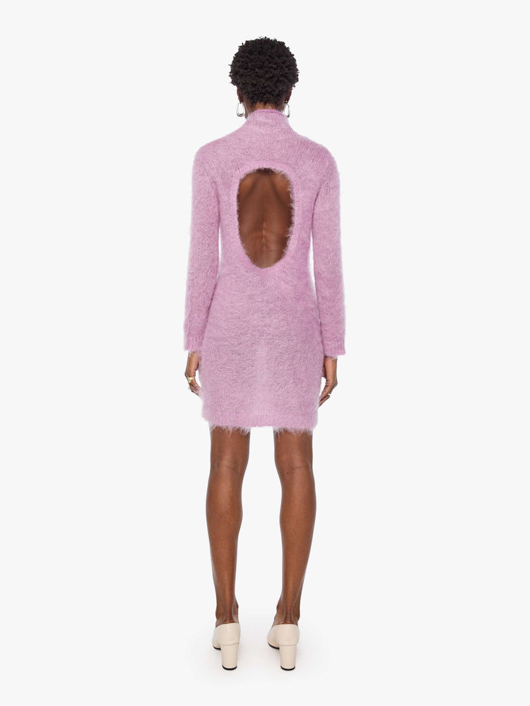 Back view of a woman in a light lavender mini dress with a soft turtleneck, long sleeves, an open back and a thigh-grazing hem.