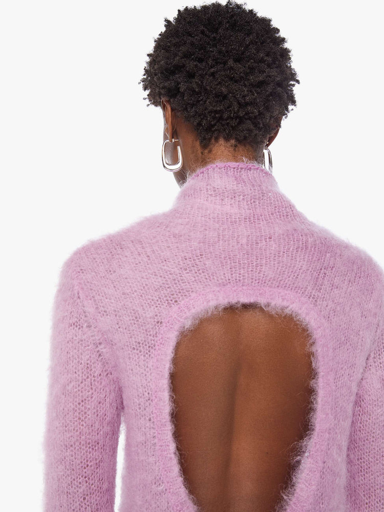 Back close up view of a woman in a light lavender mini dress with a soft turtleneck, long sleeves, an open back and a thigh-grazing hem.