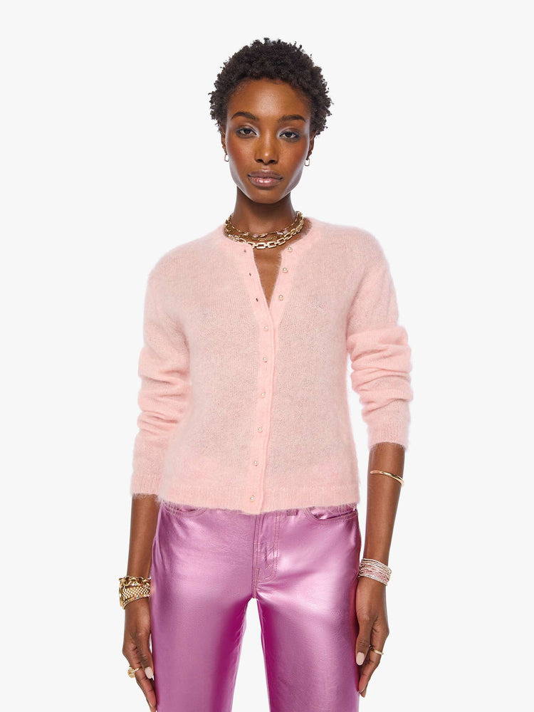 Front view of a woman in a soft baby pink crewneck, ribbed hems and a cropped fit.