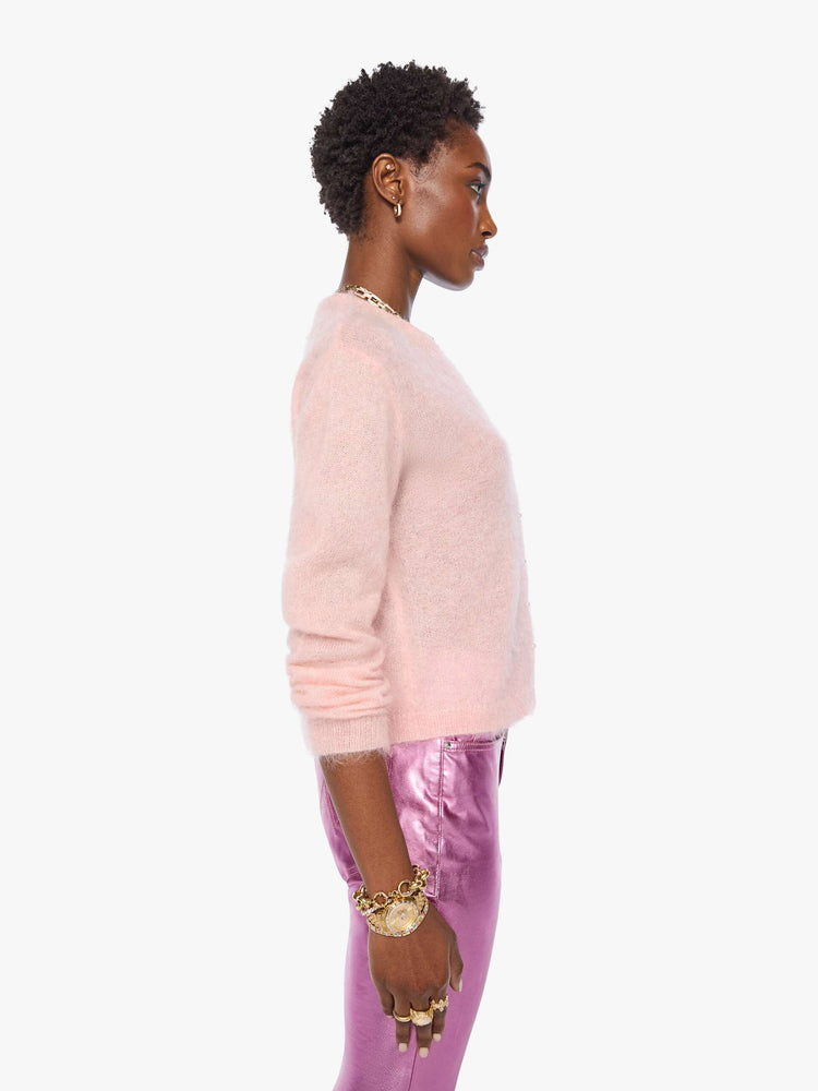Side view of a woman in a soft baby pink crewneck, ribbed hems and a cropped fit.