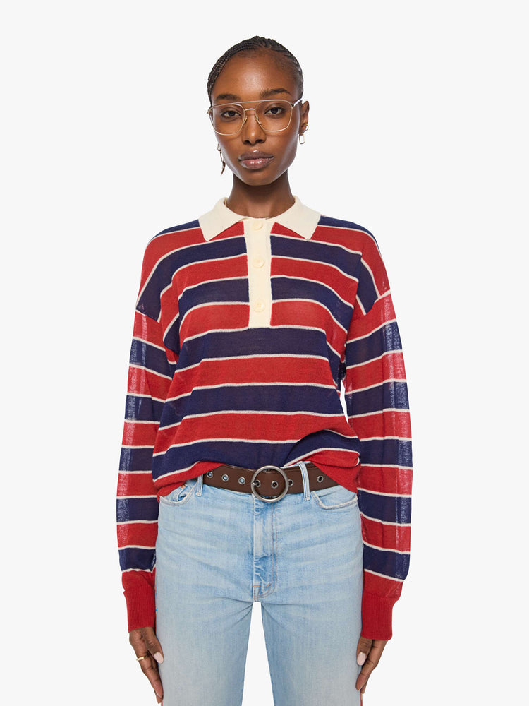 Front view of a woman in a red and navy stripes with a cream collar and button placket rugby polo with this long-sleeve top featuring drop shoulders and an oversized fit.