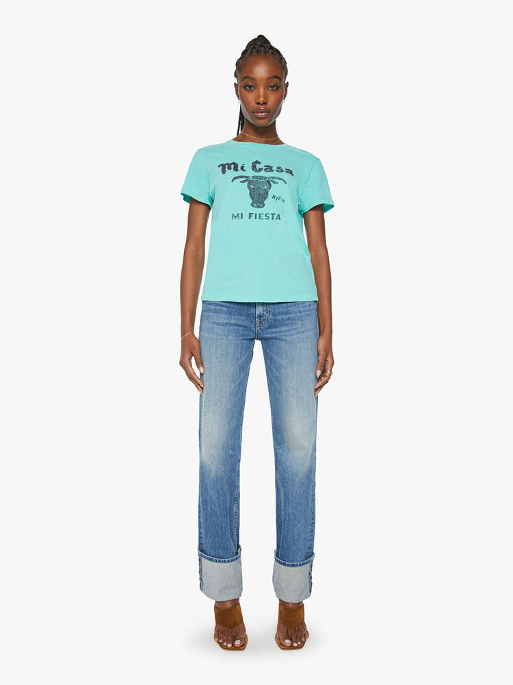 Full body view of a woman aqua blue tee featuring a faded text graphic with a bull on the front.