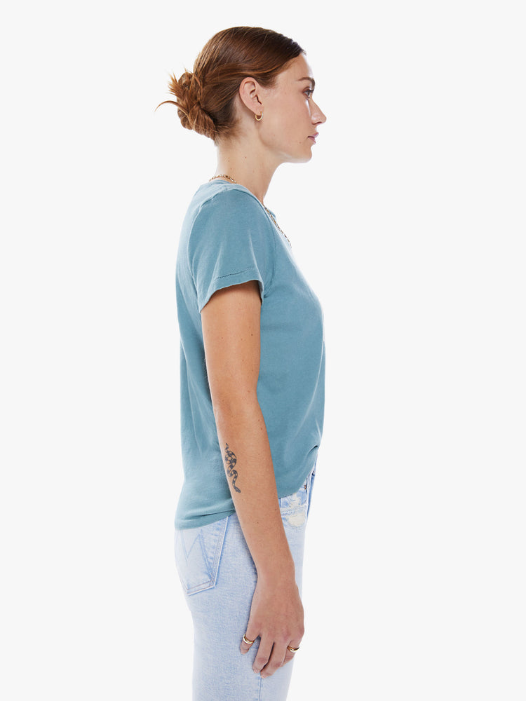 Side view of a woman slightly sheer crewneck with a slim fit in a light turquoise hue features faded text in white.