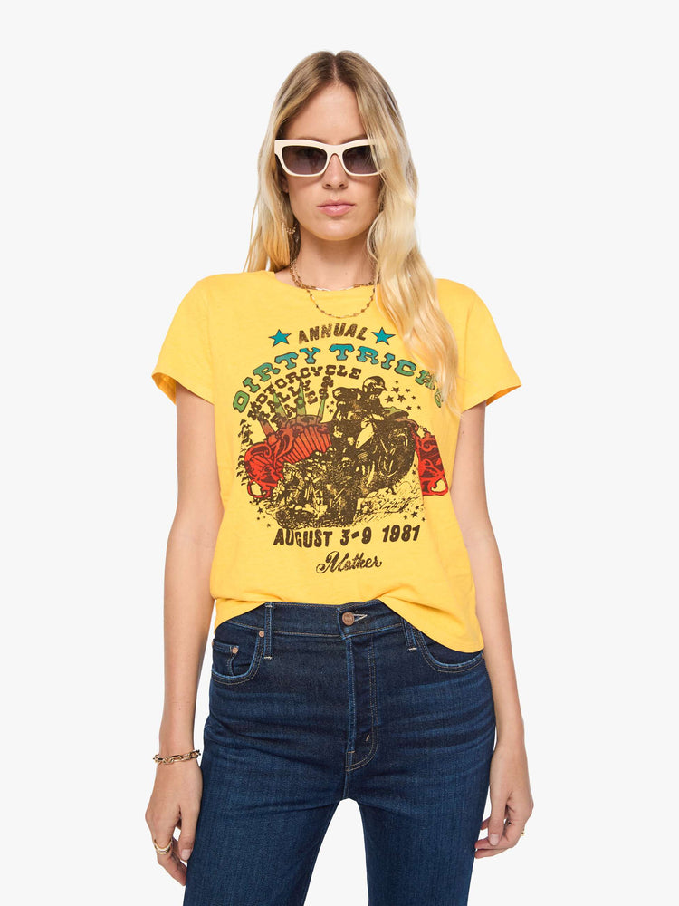 Front view of a woman in a golden yellow tee features a colorful graphic inspired by motorcycle rally race merch.
