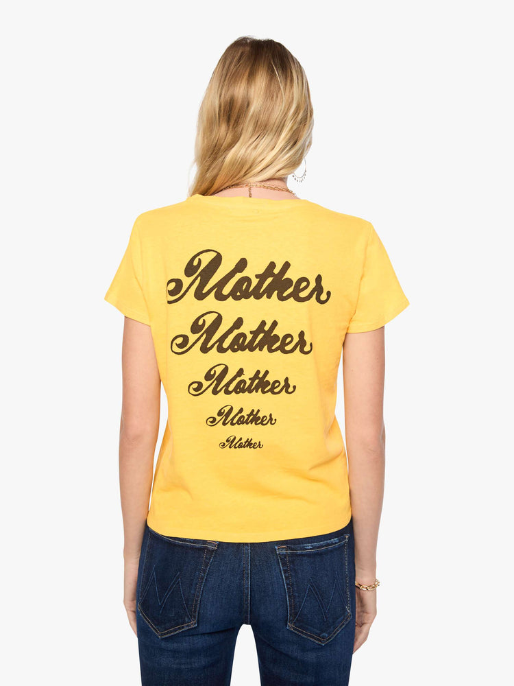 Back view of a woman in a golden yellow tee features a colorful graphic inspired by motorcycle rally race merch.