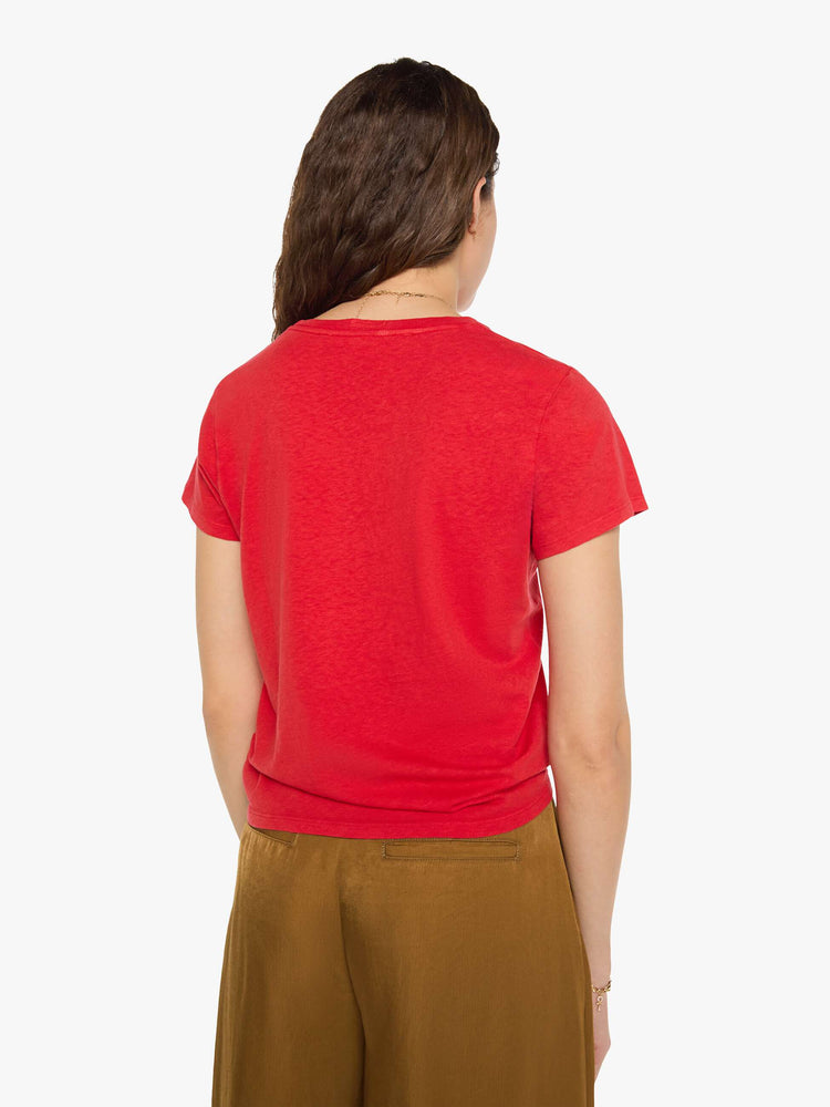 Back view of a woman in red tee features a bird graphic and text in grey on the front.