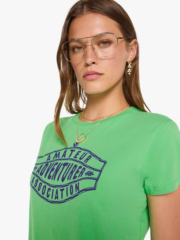 Close up view of a woman in a lime green tee with a navy text graphic on the front.