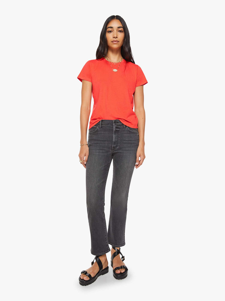 Full body view of a woman in a bright orange crewneck with a slim fit for a vintage look and feel.