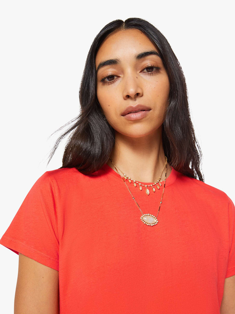 Close up view of a woman in a bright orange crewneck with a slim fit for a vintage look and feel.