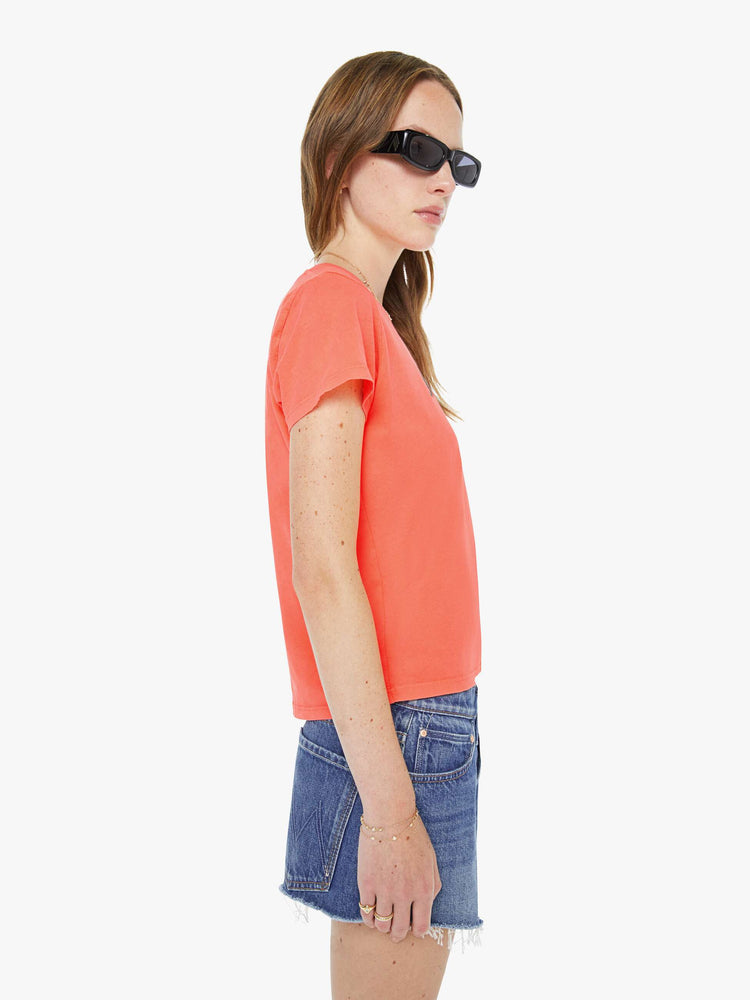 Side view of a woman in a neon orange tee features MOTHER's name in green on the front. 