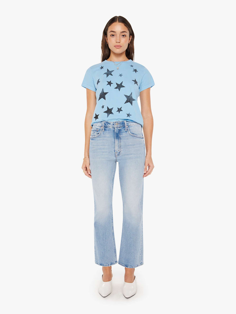 Full body view of a woman crewneck in baby blue with faded black stars throughout.