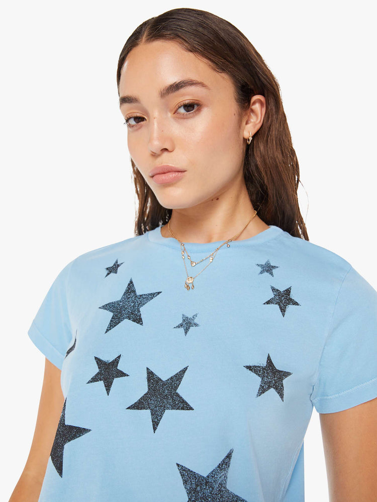 Close up view of a woman crewneck in baby blue with faded black stars throughout.