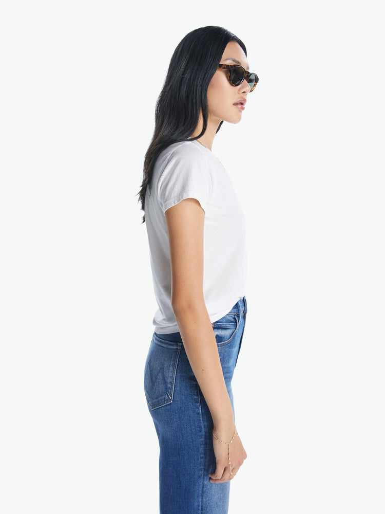 A side view of a woman wearing a fitted white crew neck tee, paired with a medium blue wash jean.