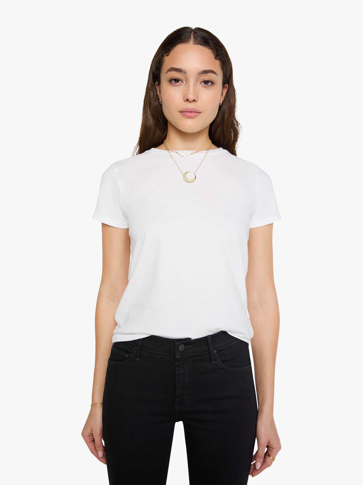 A front view of a woman wearing a fitted white crew neck tee, paired with a black wash jean.