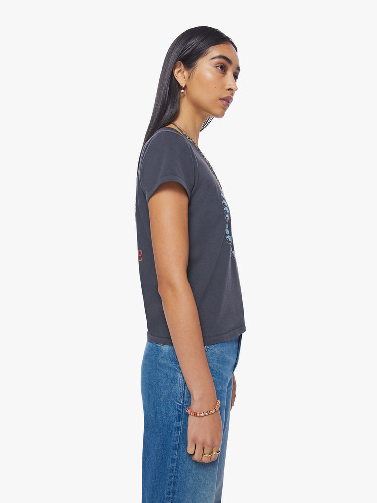 Side view of a woman slight sheer crewneck with a gradient text graphic on the front and an acronym on the back.