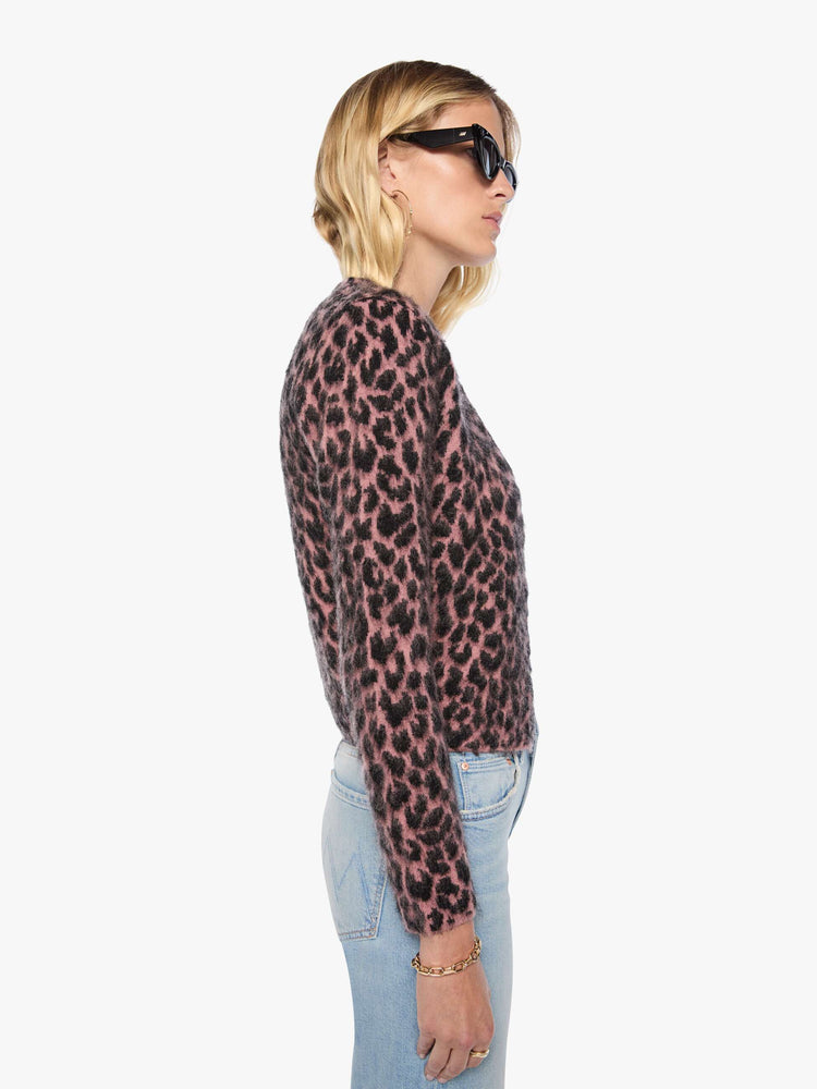 Side view of a woman in a pink and black cheetah print with a brushed finish V-neck cardigan with a cropped hem and buttons down the front.