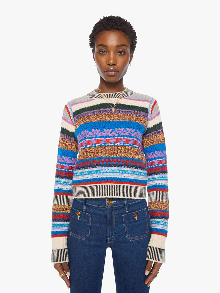 Front view of a woman in a multicolored stripes with knit details crewneck sweater with extra-long sleeves and a cropped fit.