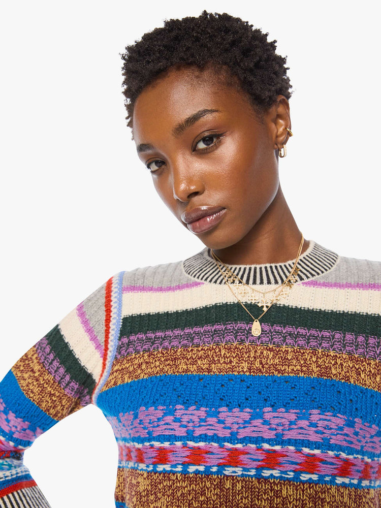 Close up view of a woman in a multicolored stripes with knit details crewneck sweater with extra-long sleeves and a cropped fit.