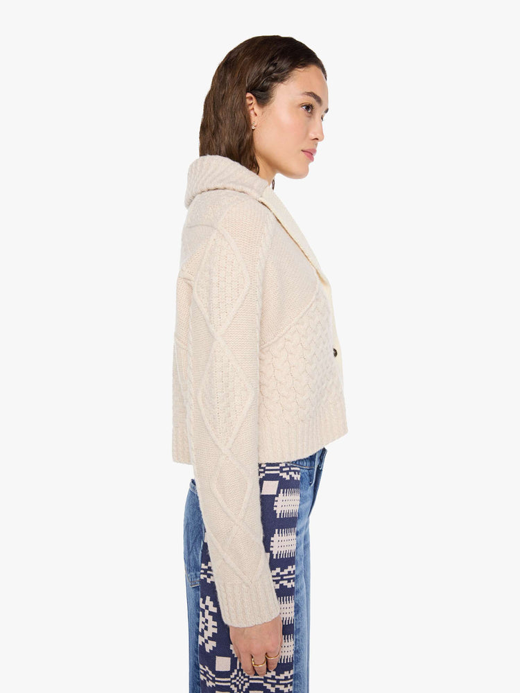 Side view of a woman in a chunky cardigan with a shawl collar, V-neck, 3-button closure, ribbed hems and a slightly cropped fit. 