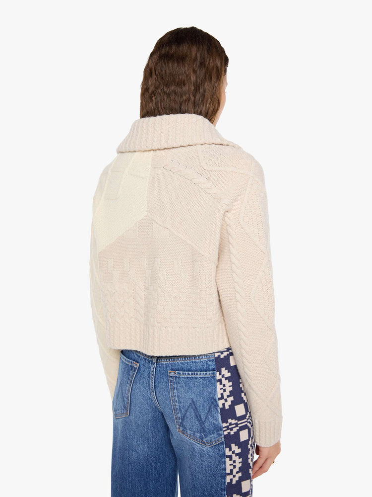 Back view of a woman in a chunky cardigan with a shawl collar, V-neck, 3-button closure, ribbed hems and a slightly cropped fit. 