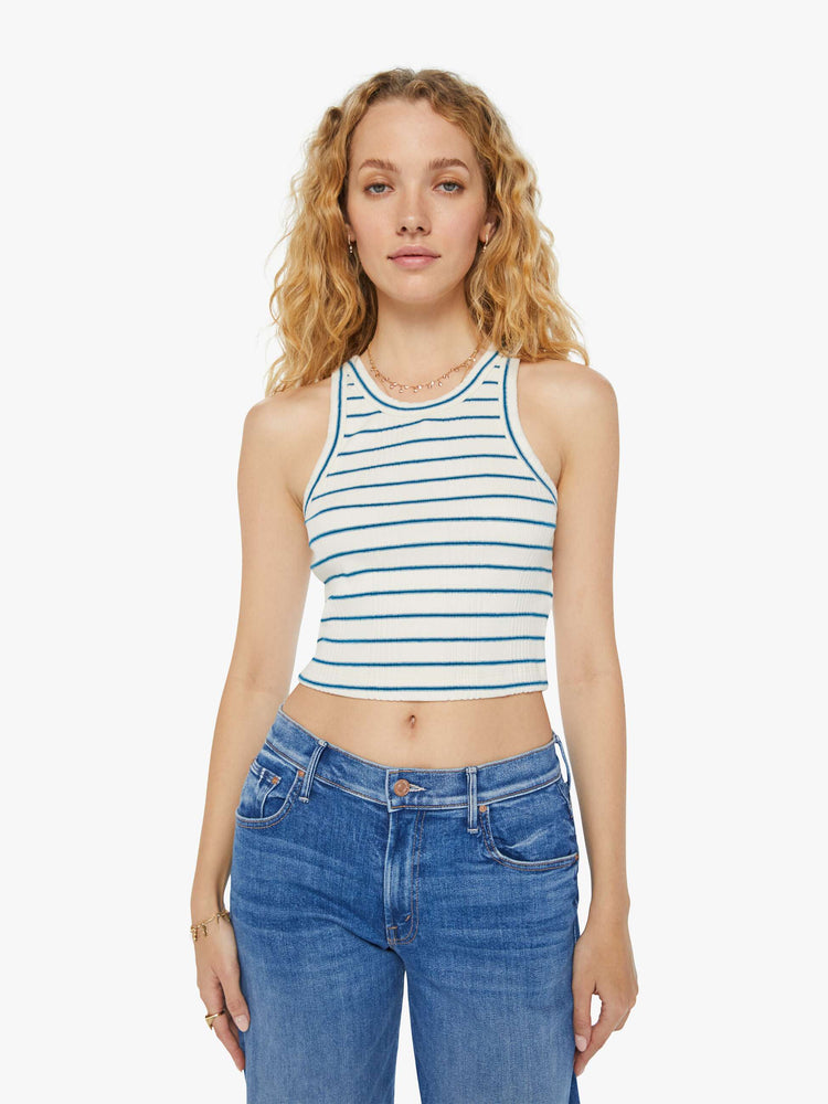Front view of a woman in a ribbed off-white with blue stripes tank top that features a slim fit, racer-style straps and a clean hem.