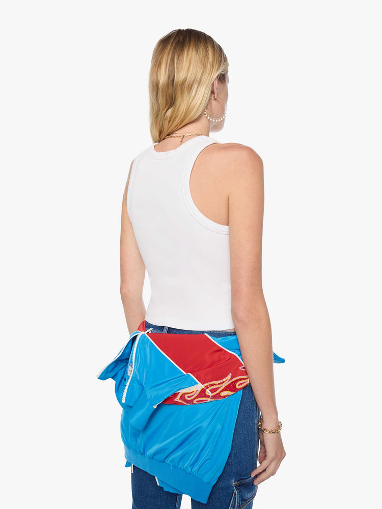 Back view of a woman in a cropped tank white with an airbrushed stencil text graphic of MOTHER's name in green on the front.