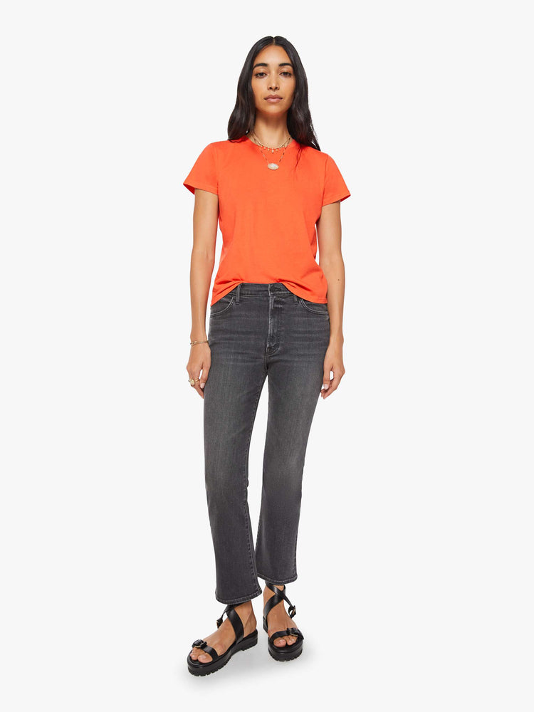 Full body view of a woman in a bright orange crewneck with a slim fit for a vintage look and feel.