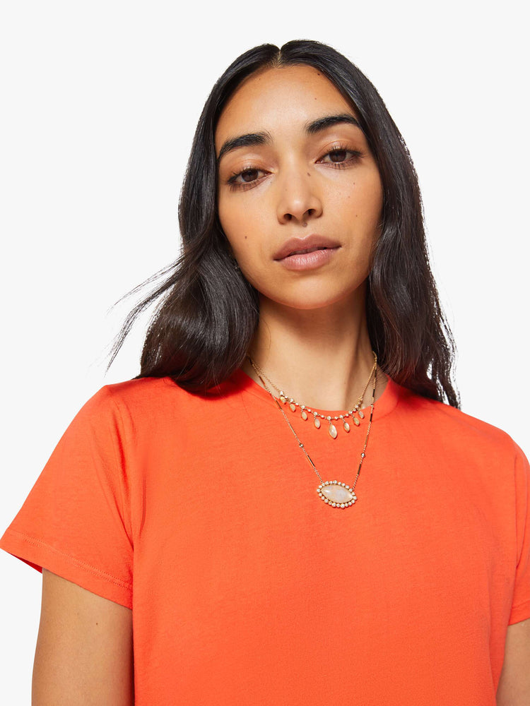 Close up view of a woman in a bright orange crewneck with a slim fit for a vintage look and feel.