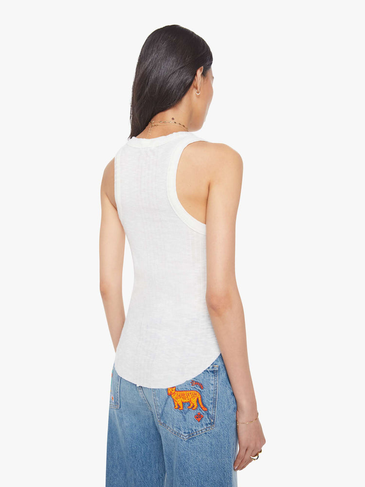 Back view of a woman in a white scoop neck tank with wide straps, a narrow fit and a curved hem. 