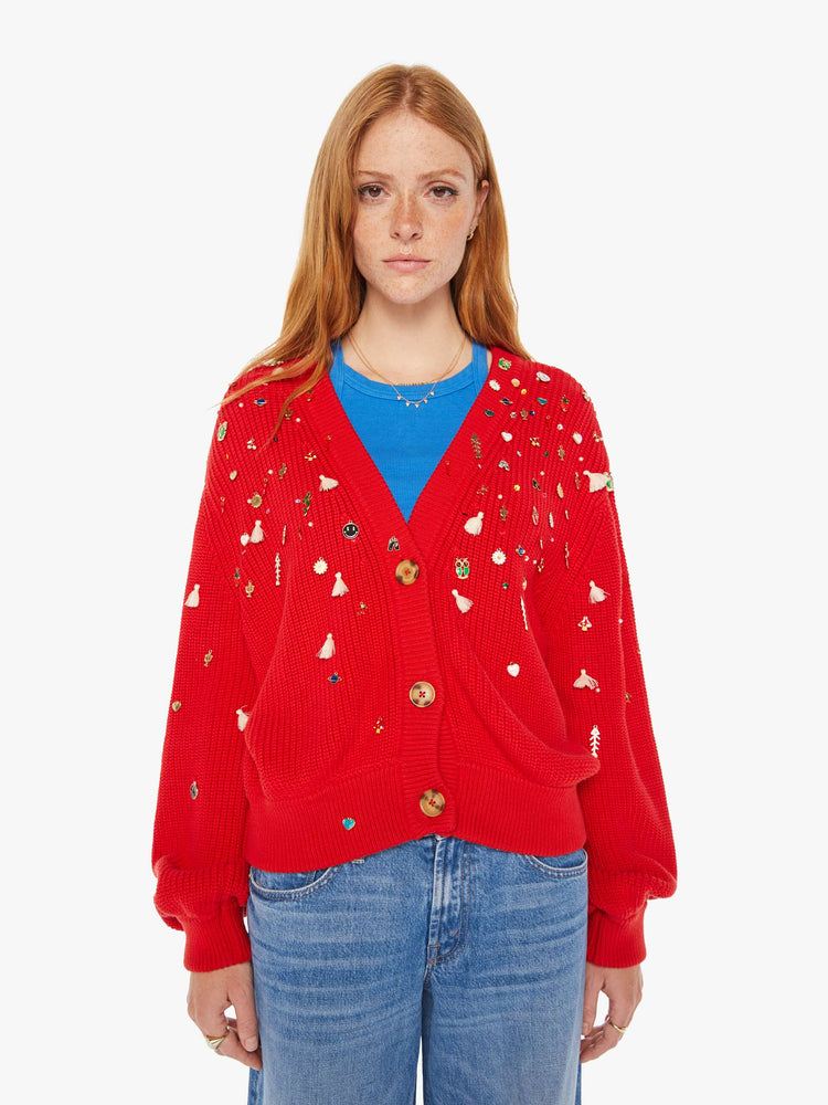 Front view of a woman red with colorful charms, beads and tassels V-neck cardigan with long balloon sleeves, drop shoulders and ribbed hems.