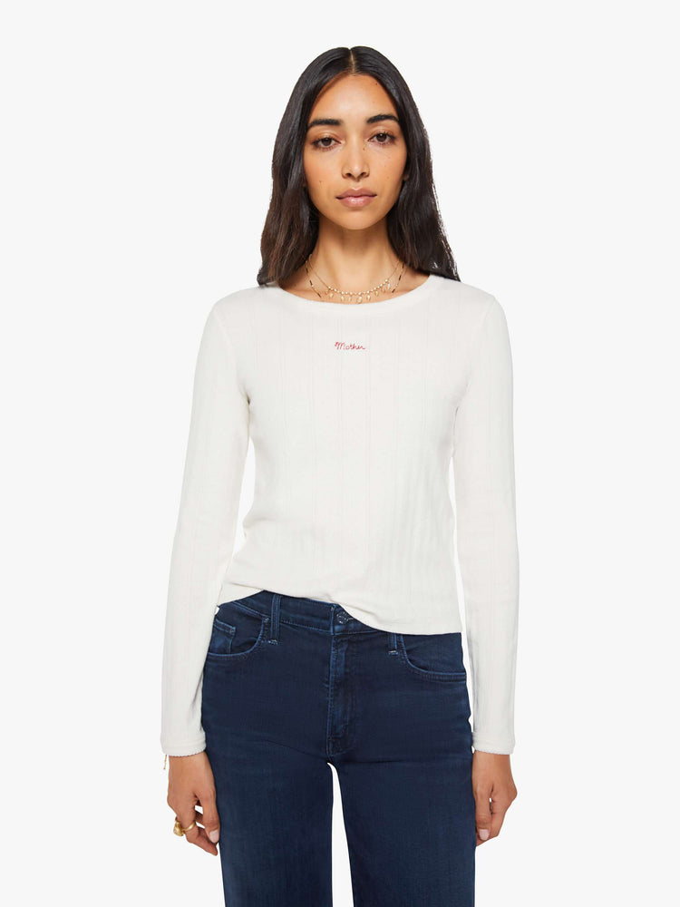 Front view of a woman in a white wth MOTHER in red detail crewneck top with long sleeves and a narrow fit. 