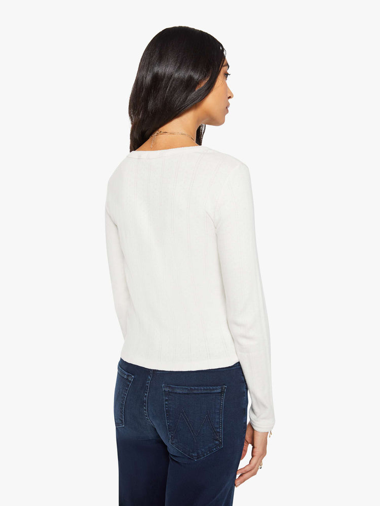 Back view of a woman in a white with MOTHER in red detail crewneck top with long sleeves and a narrow fit. 