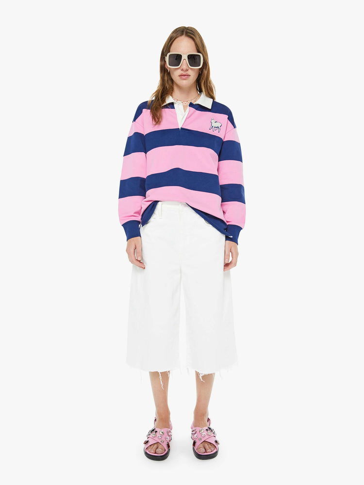 Full body view of a woman in a shirt with long sleeves, a buttoned V-neck, drop shoulders and an oversized fit.