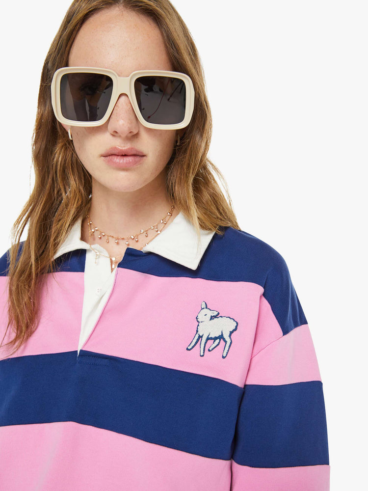 Close up view of a woman in a shirt with long sleeves, a buttoned V-neck, drop shoulders and an oversized fit.